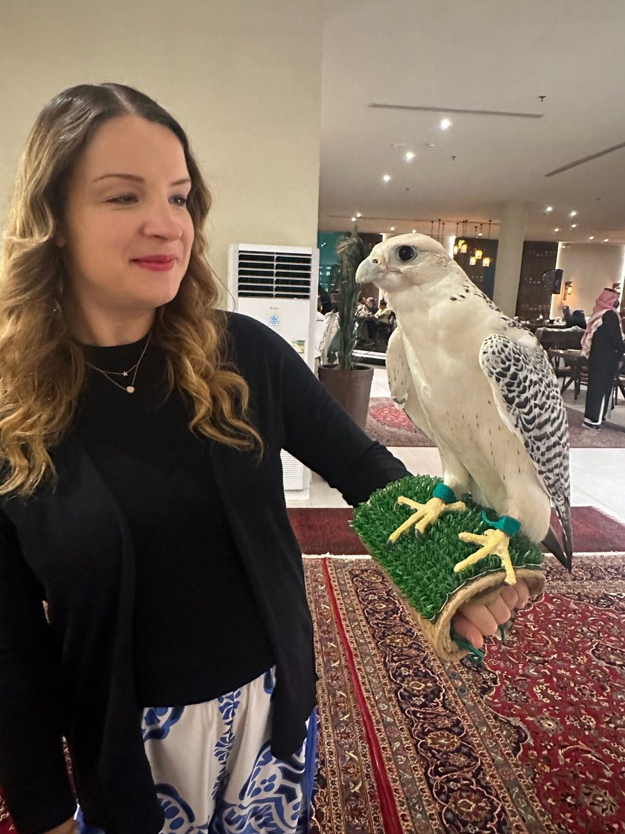 Corina Goetz holding a falcon in a traditional Saudi majlis